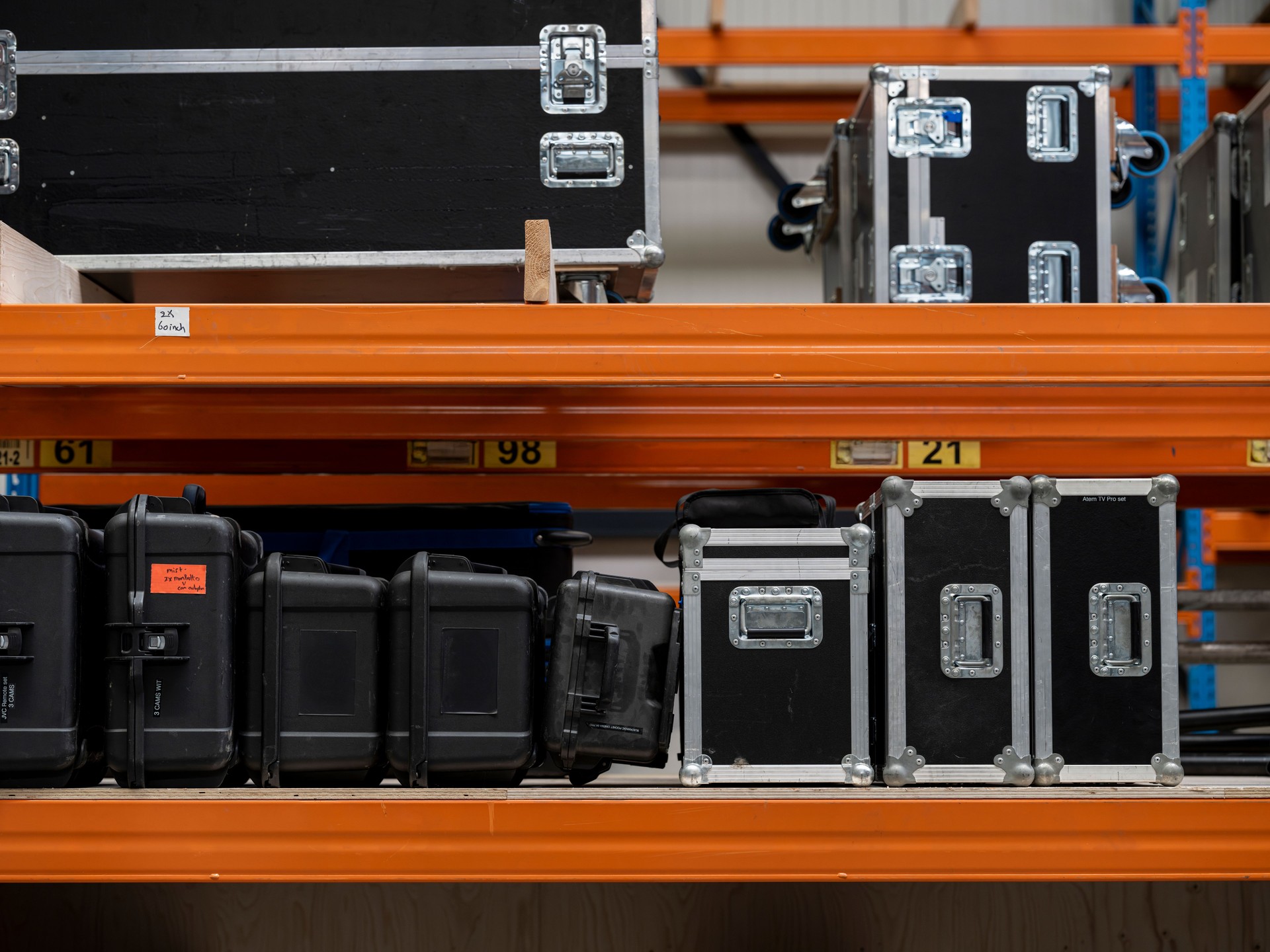 Multi-level warehouse storage showing organized flight case inventory system